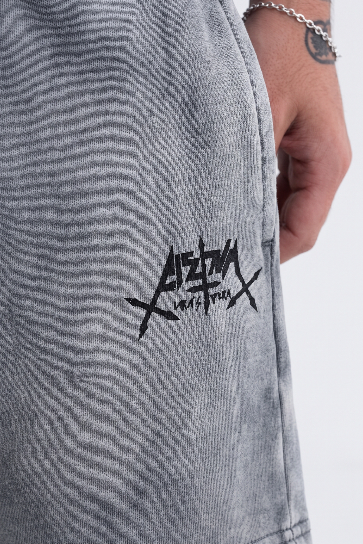 Detalhe do lettering Aspalth estampado na lateral do shorts cinza