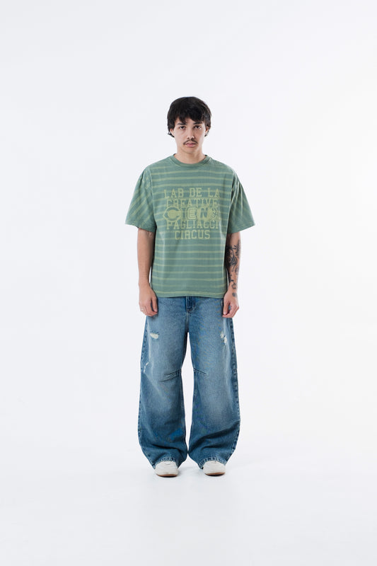 Modelo veste a Circus Staff Green Classic Tee listrada verde com calca jeans, vista frontal de corpo inteiro
