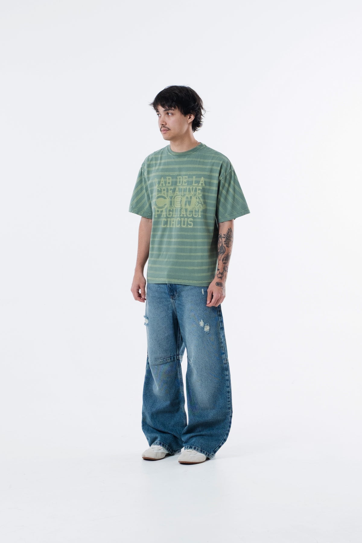 Modelo veste a Circus Staff Green Classic Tee listrada verde, vista frontal em outro angulo