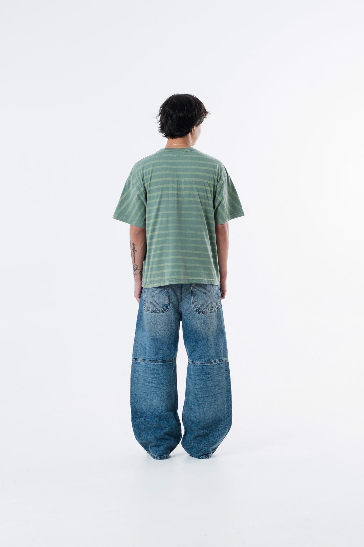 Modelo de costas vestindo a Circus Staff Green Classic Tee listrada verde