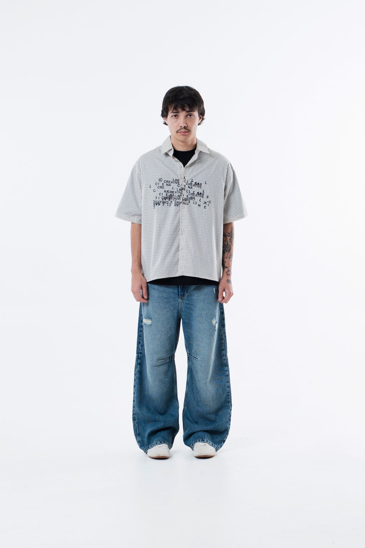 Modelo veste a Xadrez Bege Shirt com calca jeans, vista frontal de corpo inteiro