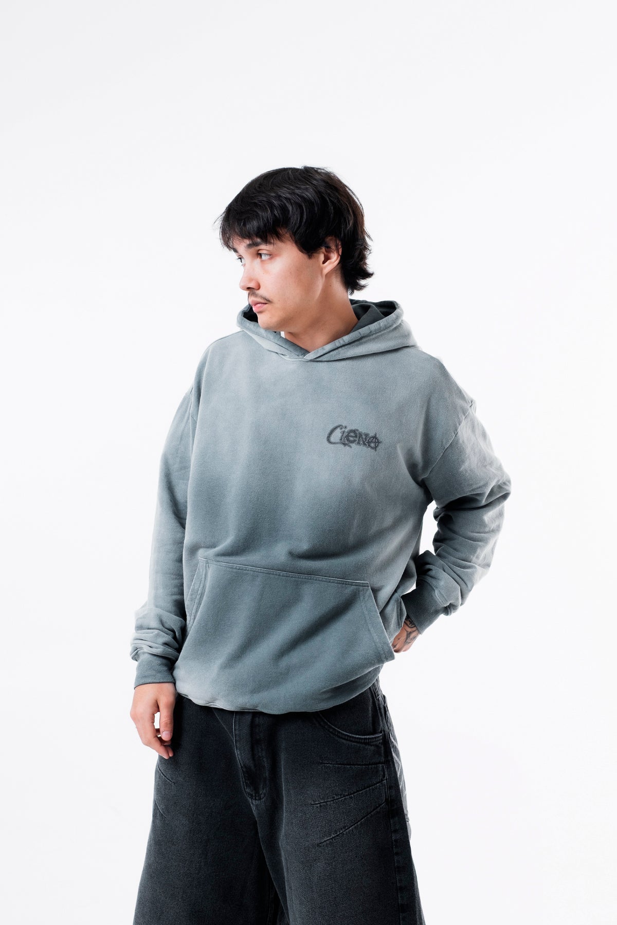 Modelo veste o Aspalth Hoodie cinza, enquadramento do tronco