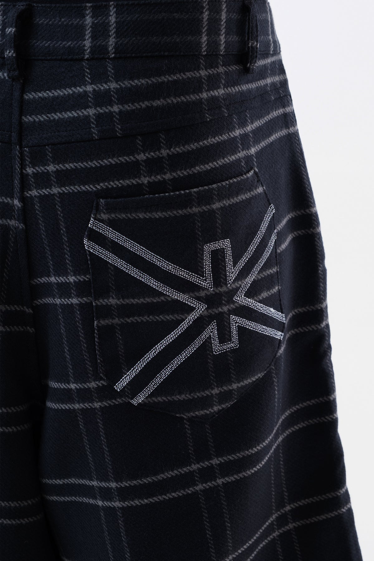Detalhe do simbolo Ciena costurado no bolso traseiro da Xadrez Long Shorts