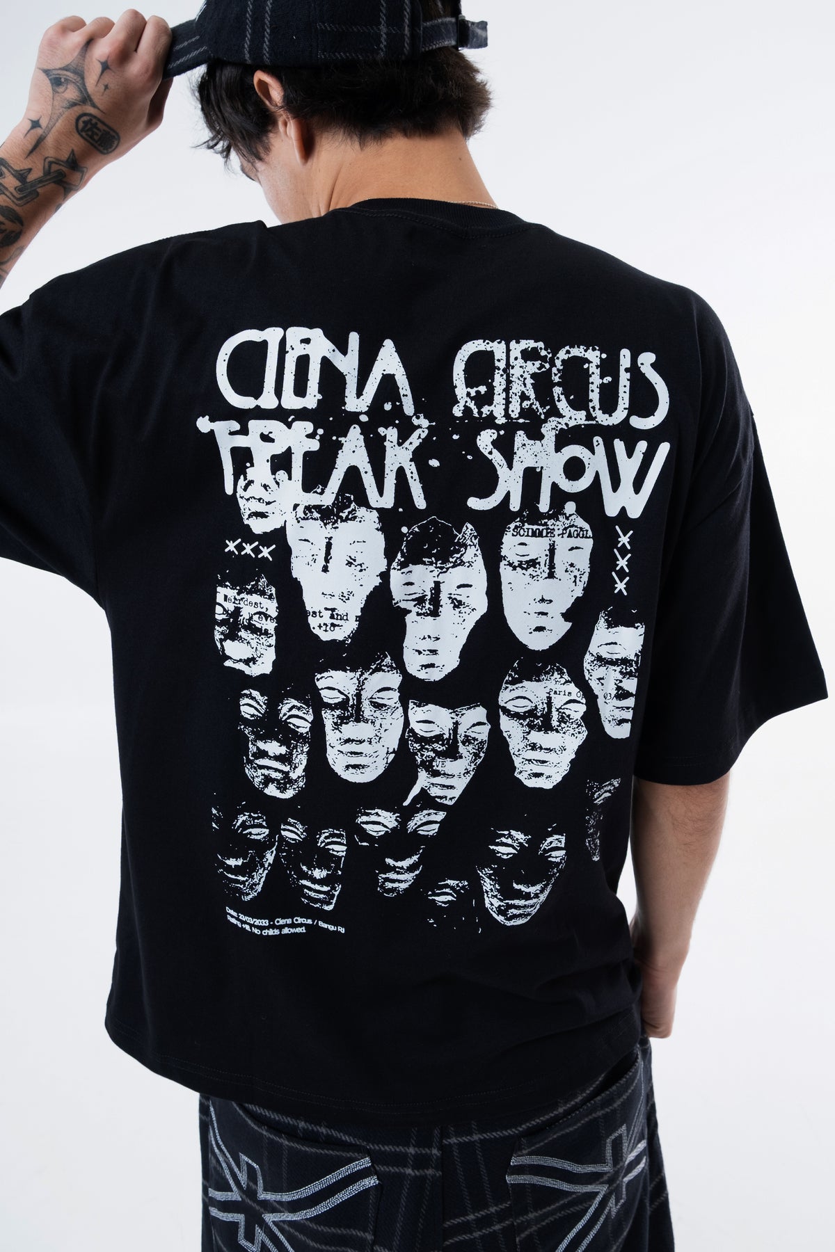 Detalhe das faces ilustradas e do lettering Ciena Circus Freak Show nas costas da camiseta