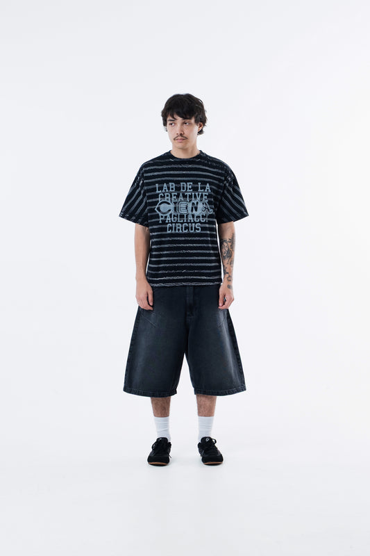 Modelo veste a Circus Staff Black Classic Tee listrada preta, vista frontal de corpo inteiro