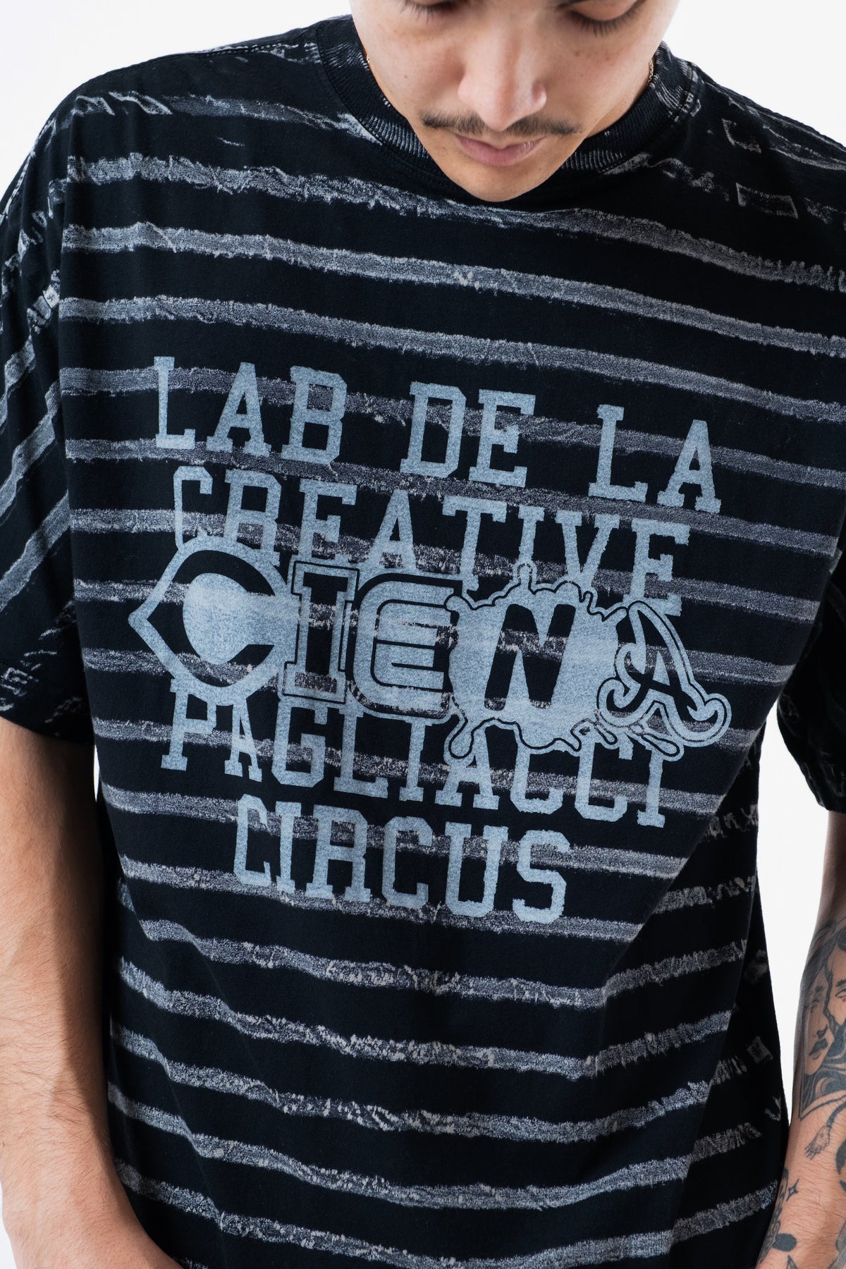 Detalhe do lettering Lab de la Creative Ciena Pagliacci Circus no peito da camiseta listrada