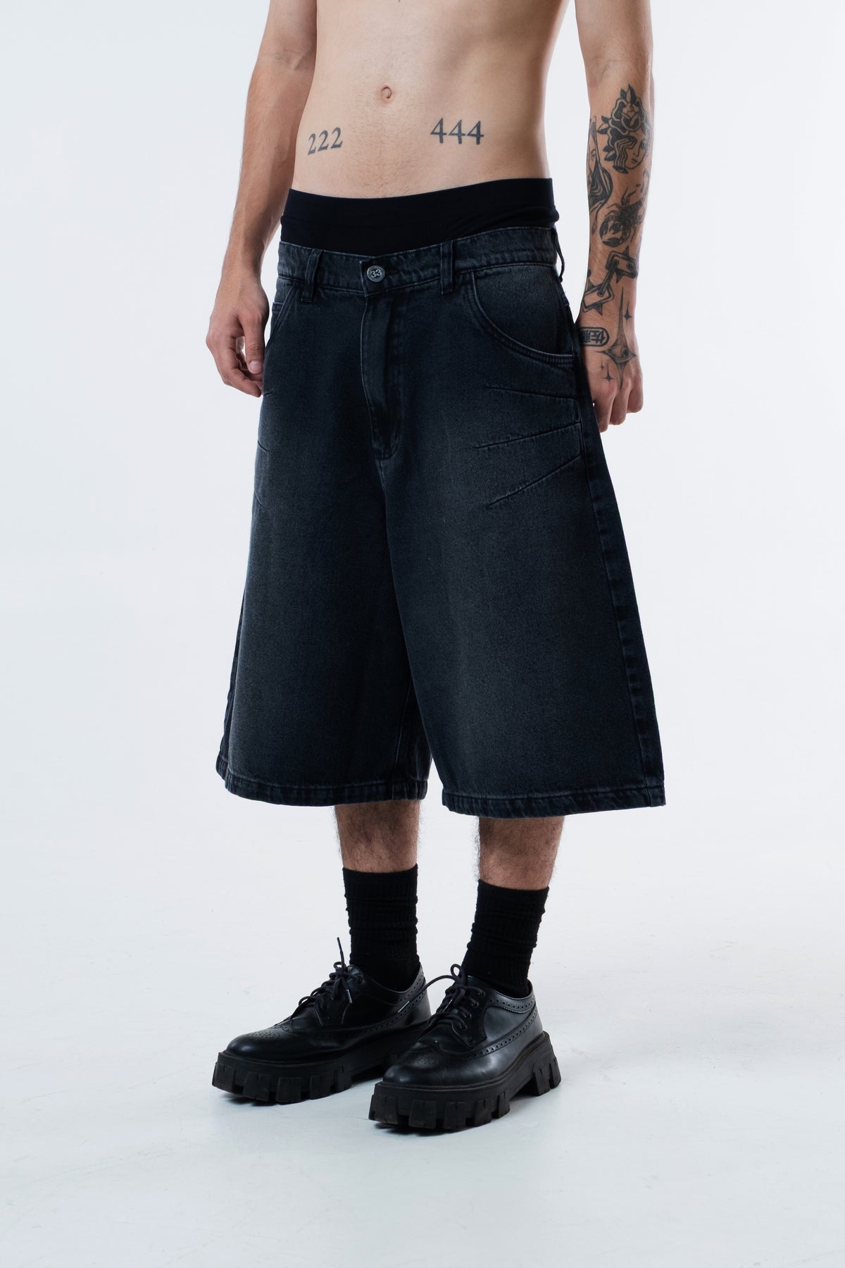 Modelo veste a Asterix Black Jorts preta, vista frontal em outro angulo