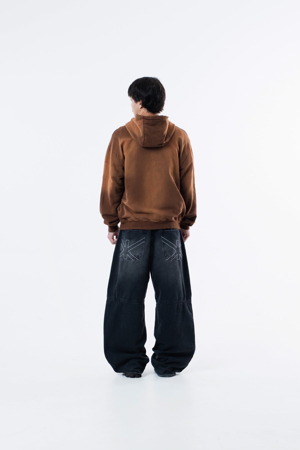 Modelo de costas vestindo o Mud Hoodie marrom com capuz