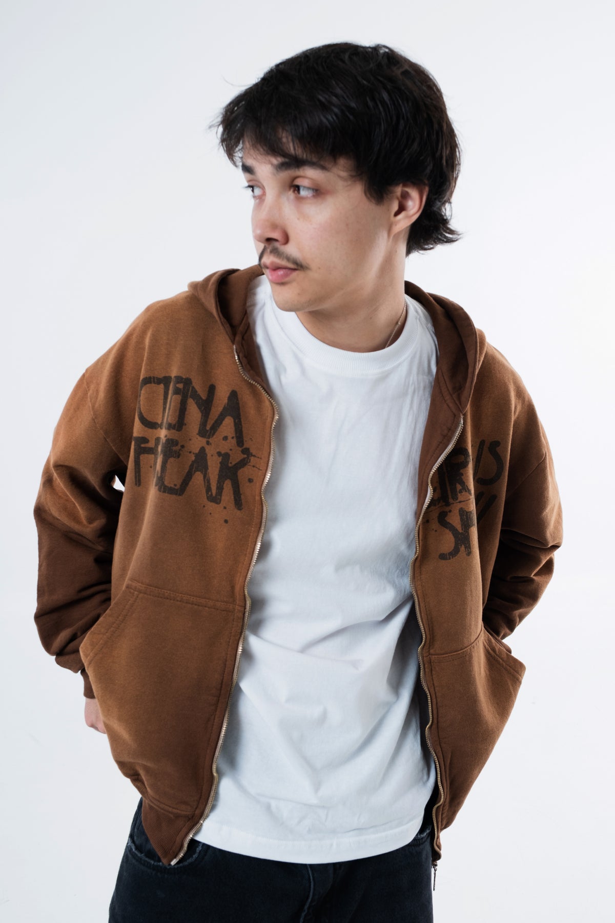 Modelo veste o Mud Hoodie marrom aberto sobre camiseta branca, enquadramento do tronco