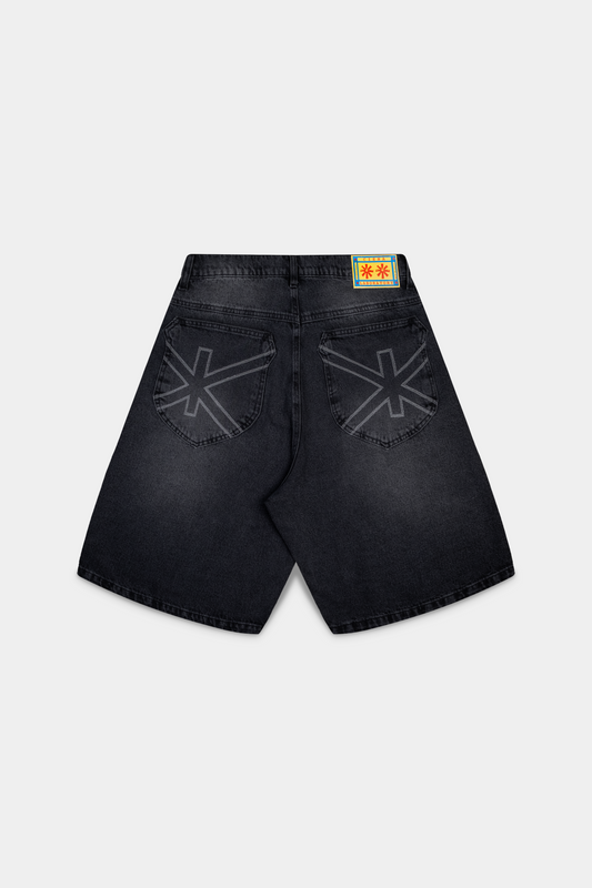 Bermuda jeans Asterix Black Jorts preta deitada, vista de tras com o simbolo Ciena nos bolsos e etiqueta