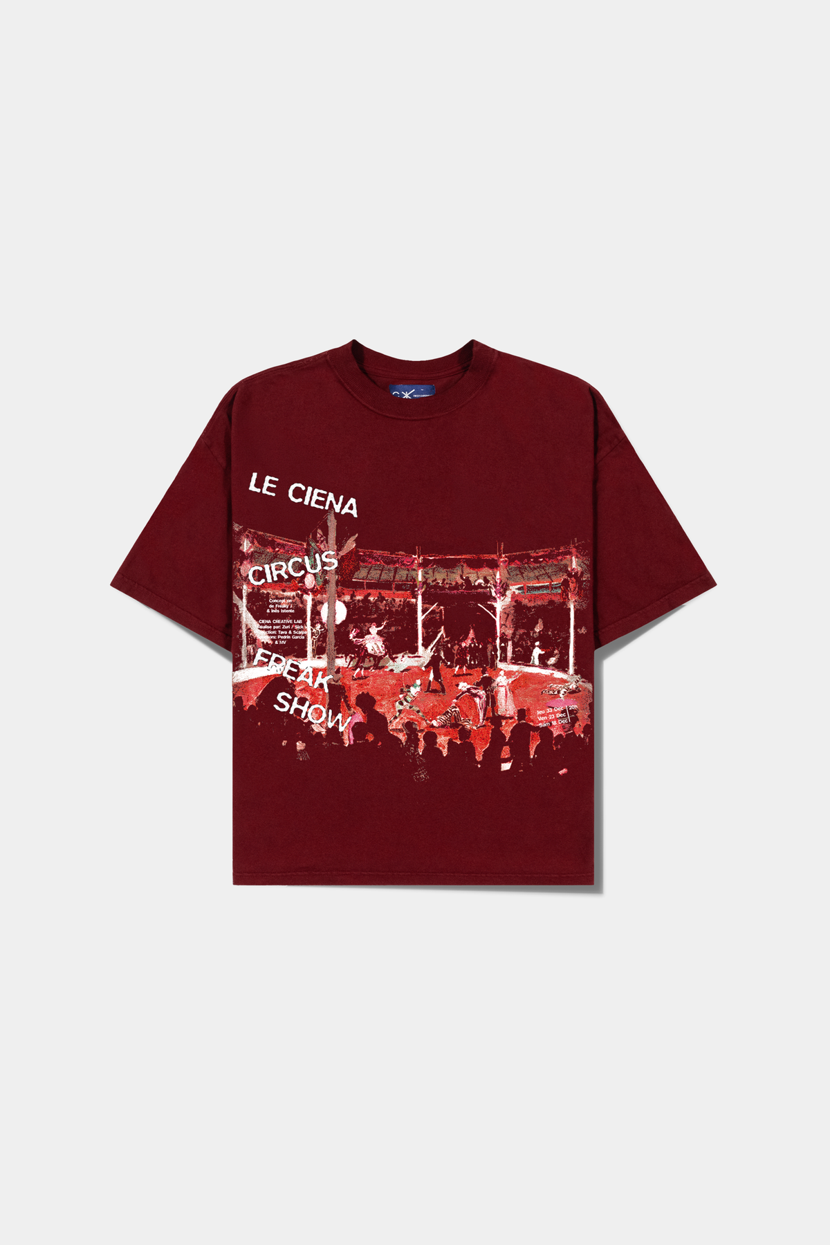 Camiseta Lo Spettacolo Red Heavy Tee vermelha deitada, com a cena de circo e o lettering Le Ciena no peito