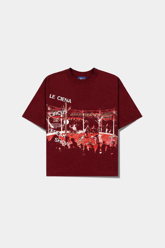 Camiseta Lo Spettacolo Red Heavy Tee vermelha deitada, com a cena de circo e o lettering Le Ciena no peito